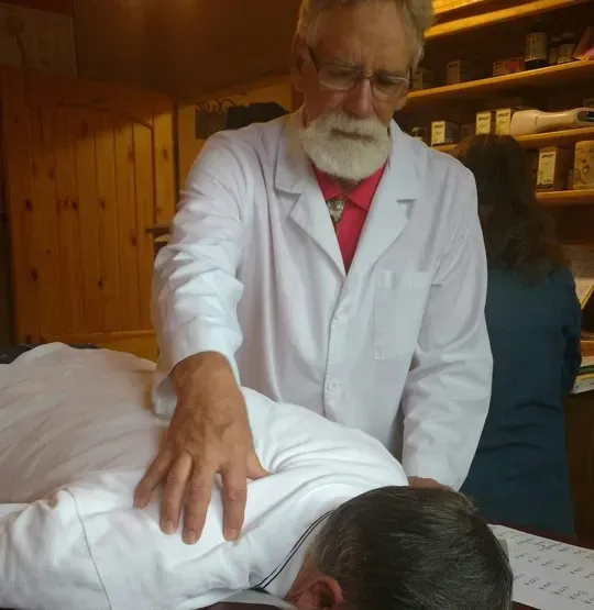A man with a beard is giving a man a massage