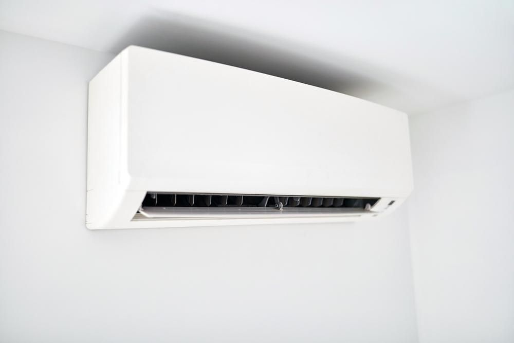 A White Air Conditioner Is Hanging From The Ceiling In A Room — Custom Air In East Albury, NSW
