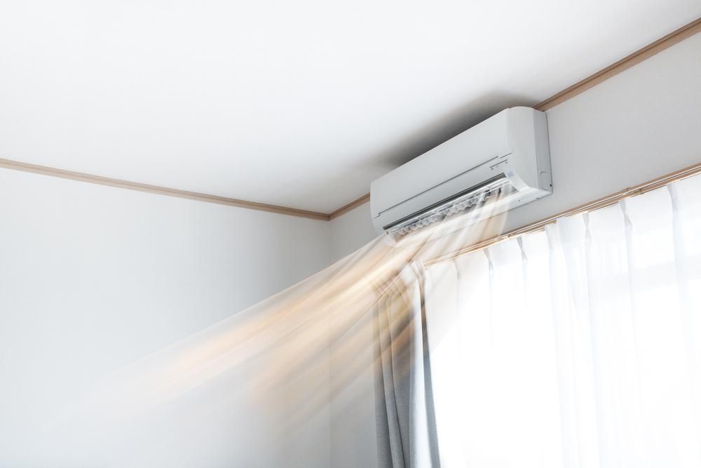 A Room Air Conditioner Is Blowing Air Out Of A Window — Custom Air In East Albury, NSW