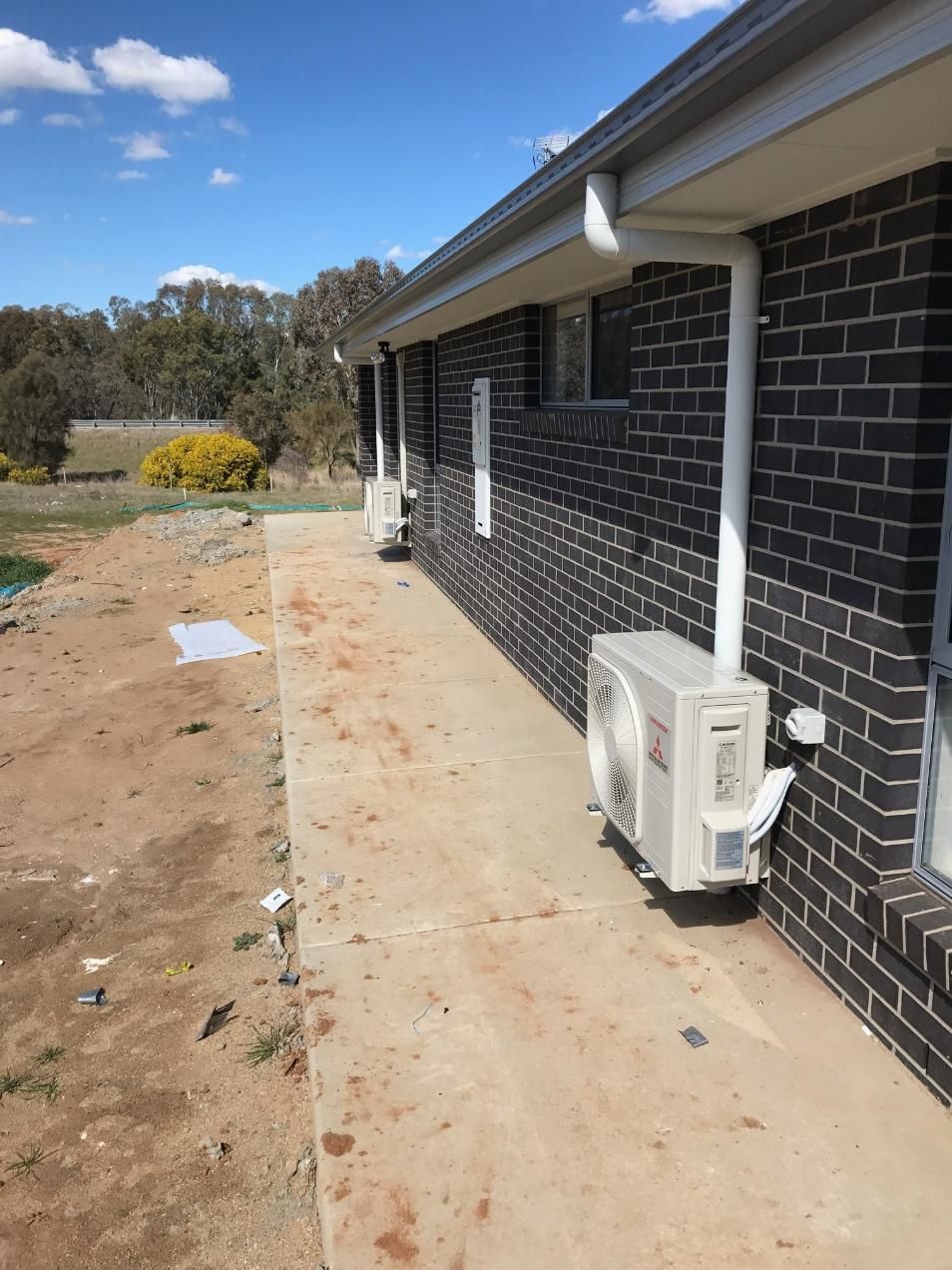 A Brick House With Two Air Conditioners On The Side Of It — Custom Air In East Albury, NSW
