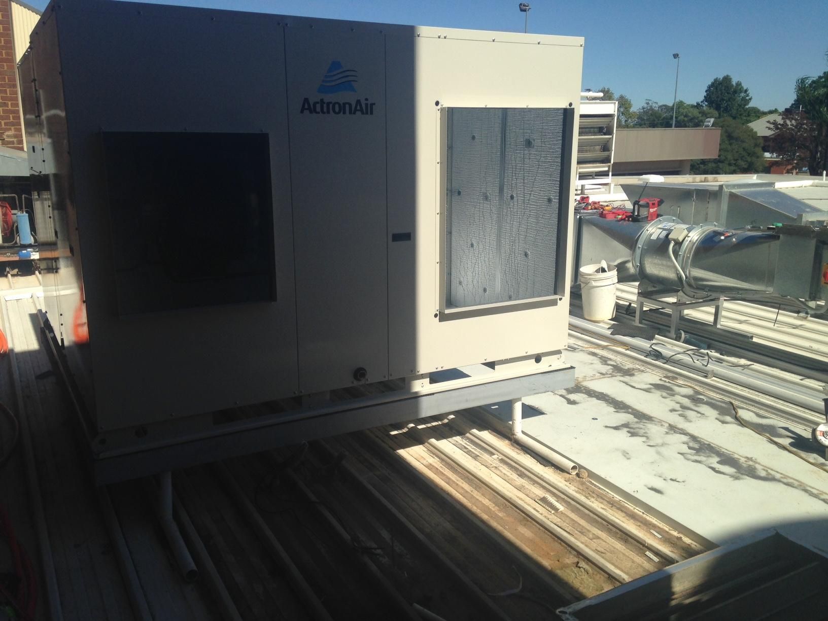 An Air Conditioner Is Sitting On The Roof Of A Building — Custom Air In East Albury, NSW