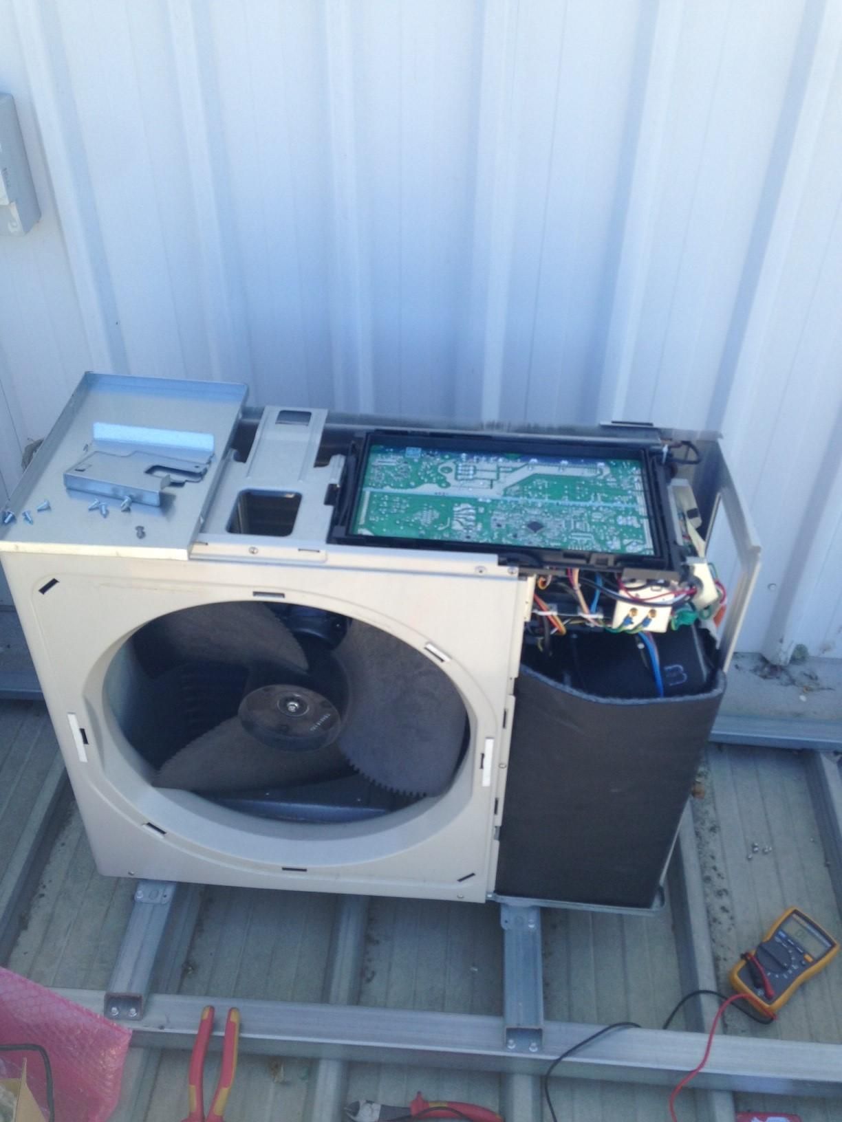 An Air Conditioner Is Being Repaired On The Roof Of A Building — Custom Air In East Albury, NSW