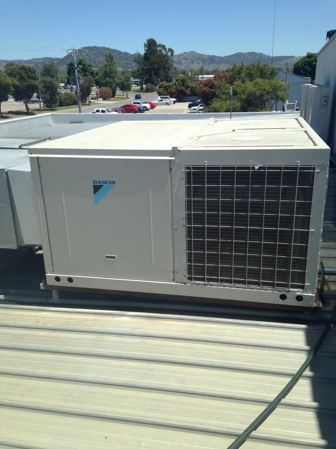 A Large Air Conditioner Is Sitting On Top Of A Roof — Custom Air In East Albury, NSW