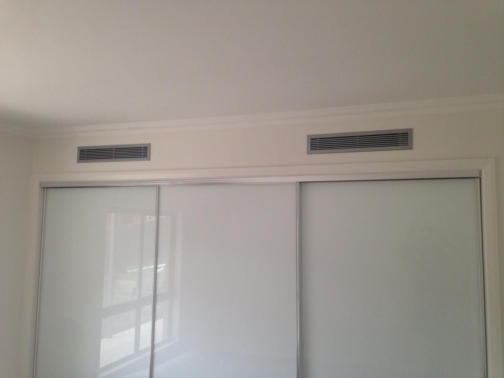 A Room With White Walls And Sliding Glass Doors — Custom Air In Albury, NSW