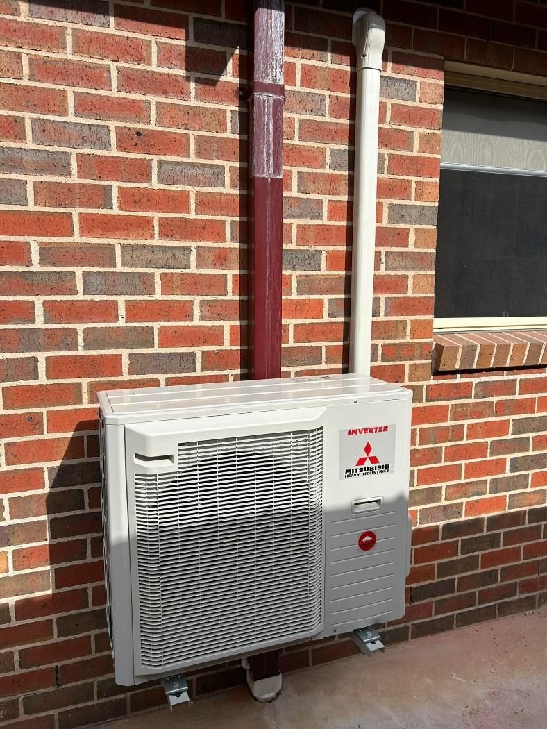 A Mitsubishi Air Conditioner Is Mounted On The Side Of A Brick Building — Custom Air In East Albury, NSW