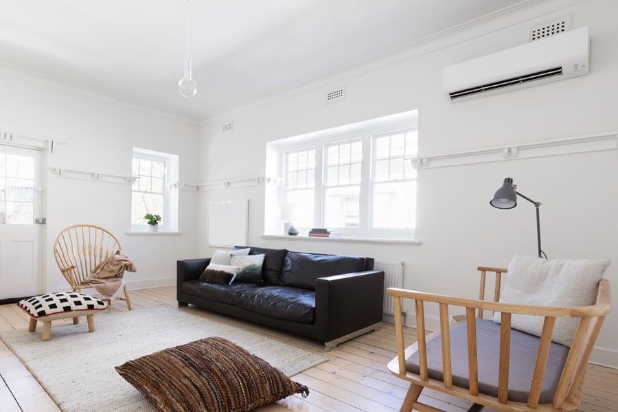 A Living Room With A Couch, Chairs, And A Fan On The Wall — Custom Air In East Albury, NSW