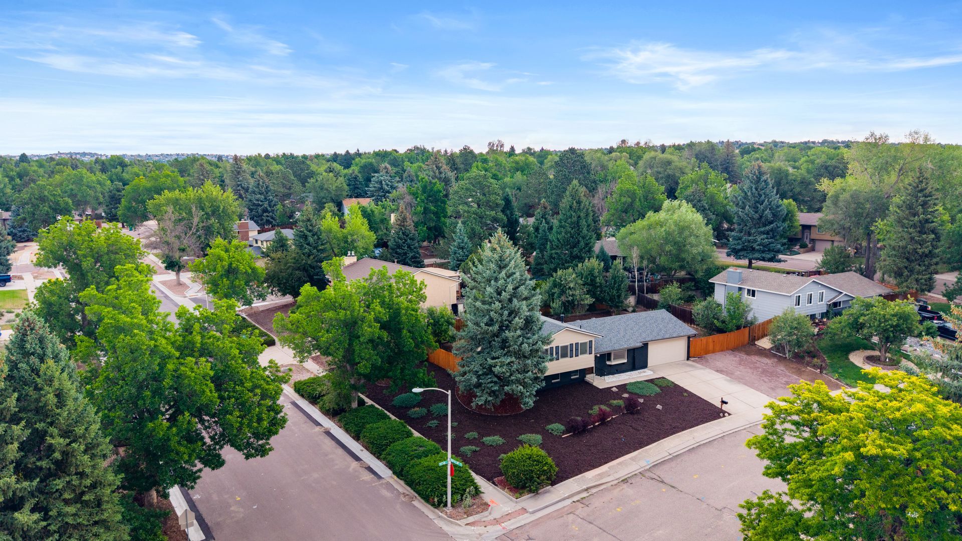 Aerial view of a suburban neighborhood with tree-lined streets and houses