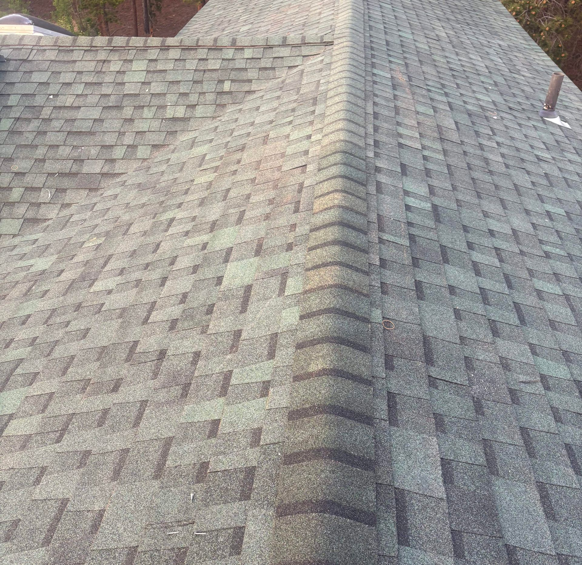 Gray shingled roof with a central ridge, viewed from above