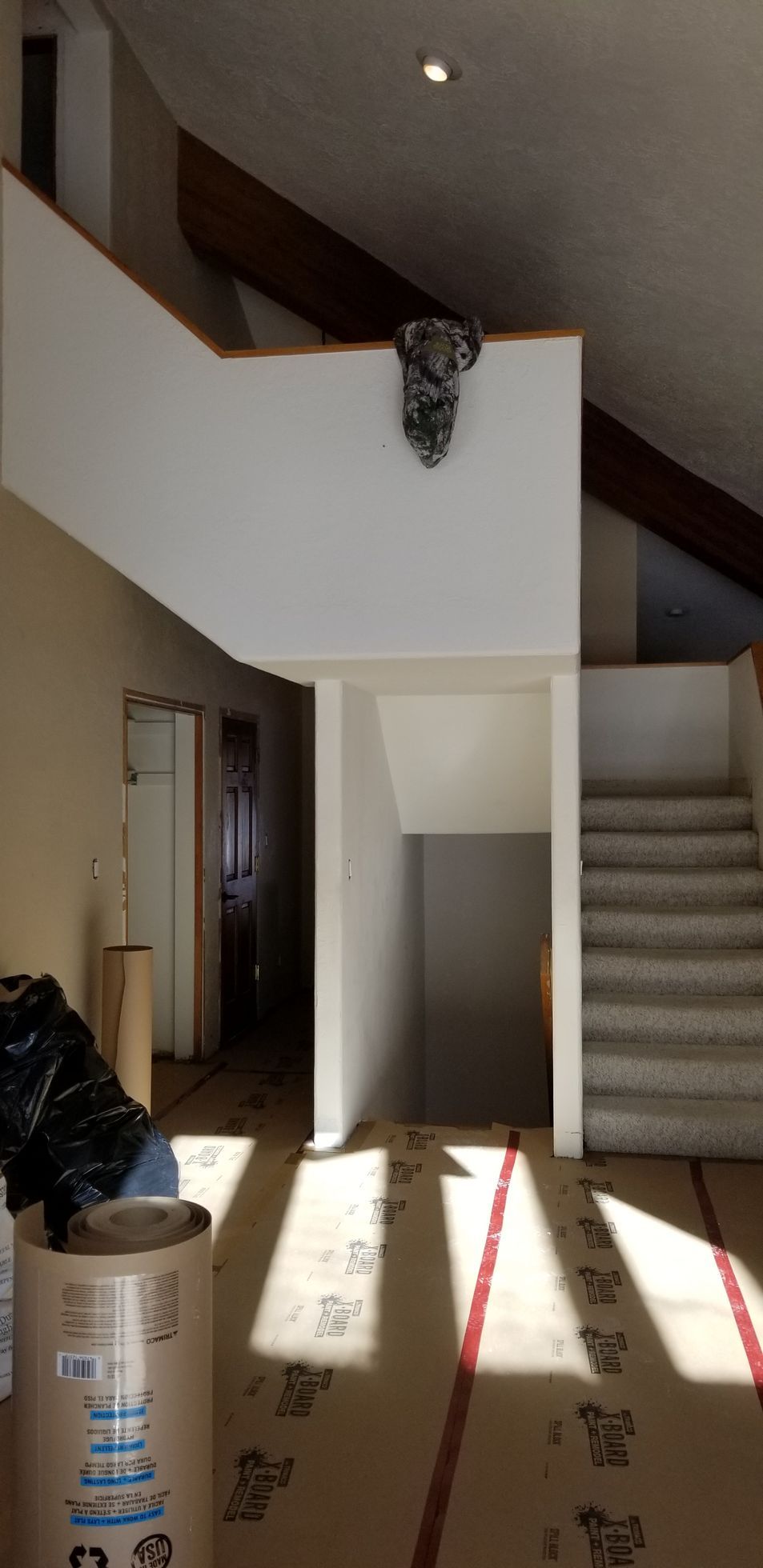 Outdated interior staircase with carpeted steps and enclosed walls before renovation.