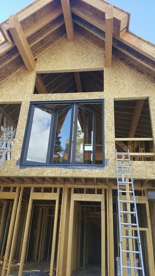 A wooden house under construction with a ladder in front of it.