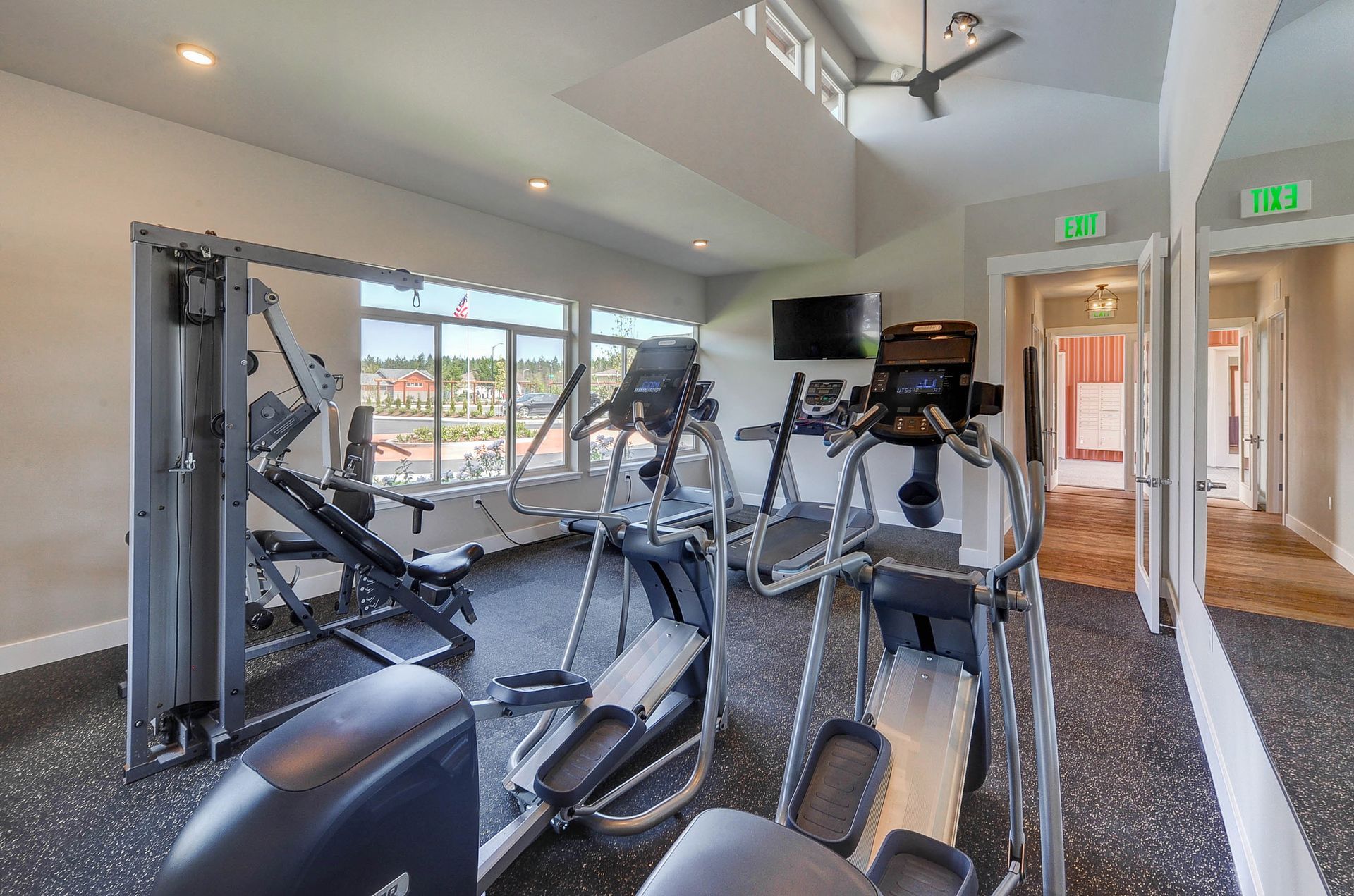 a gym with a green exit sign on the wall