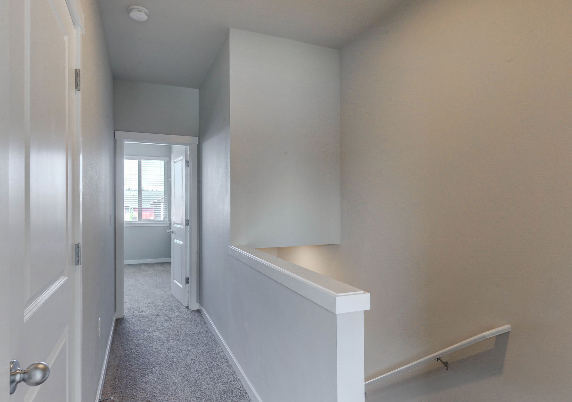 a hallway with stairs leading up to the second floor