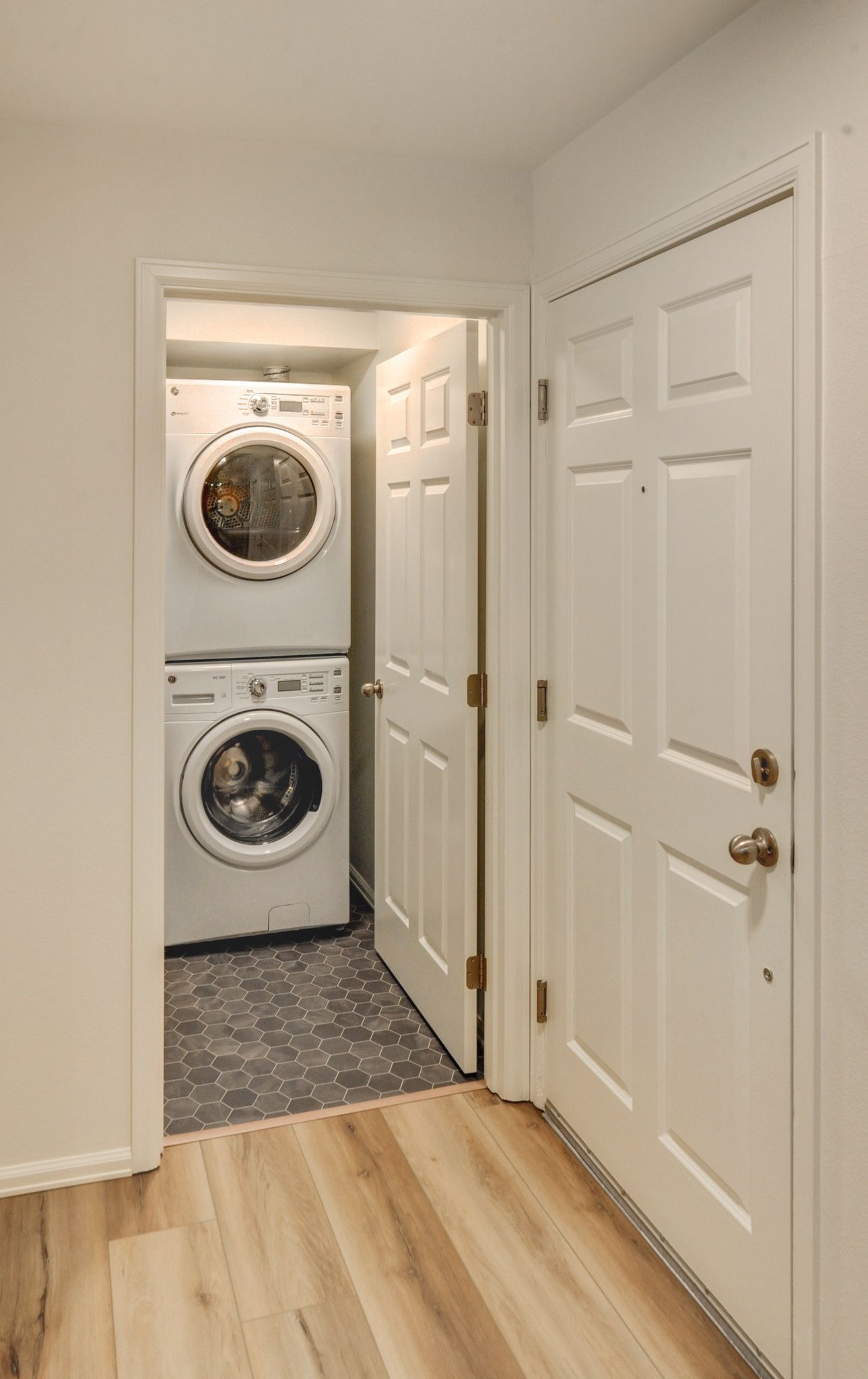 a laundry room with a washer and dryer stacked on top of each other .