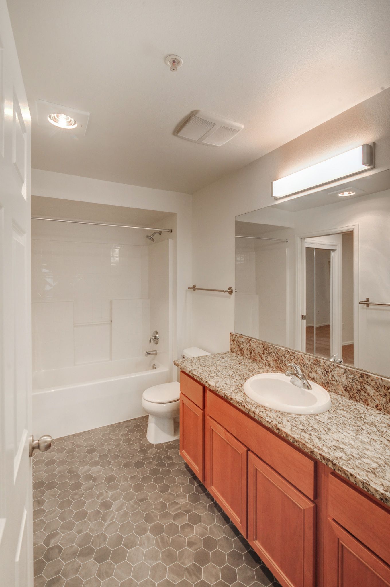 a bathroom with a sink , toilet , bathtub and mirror .