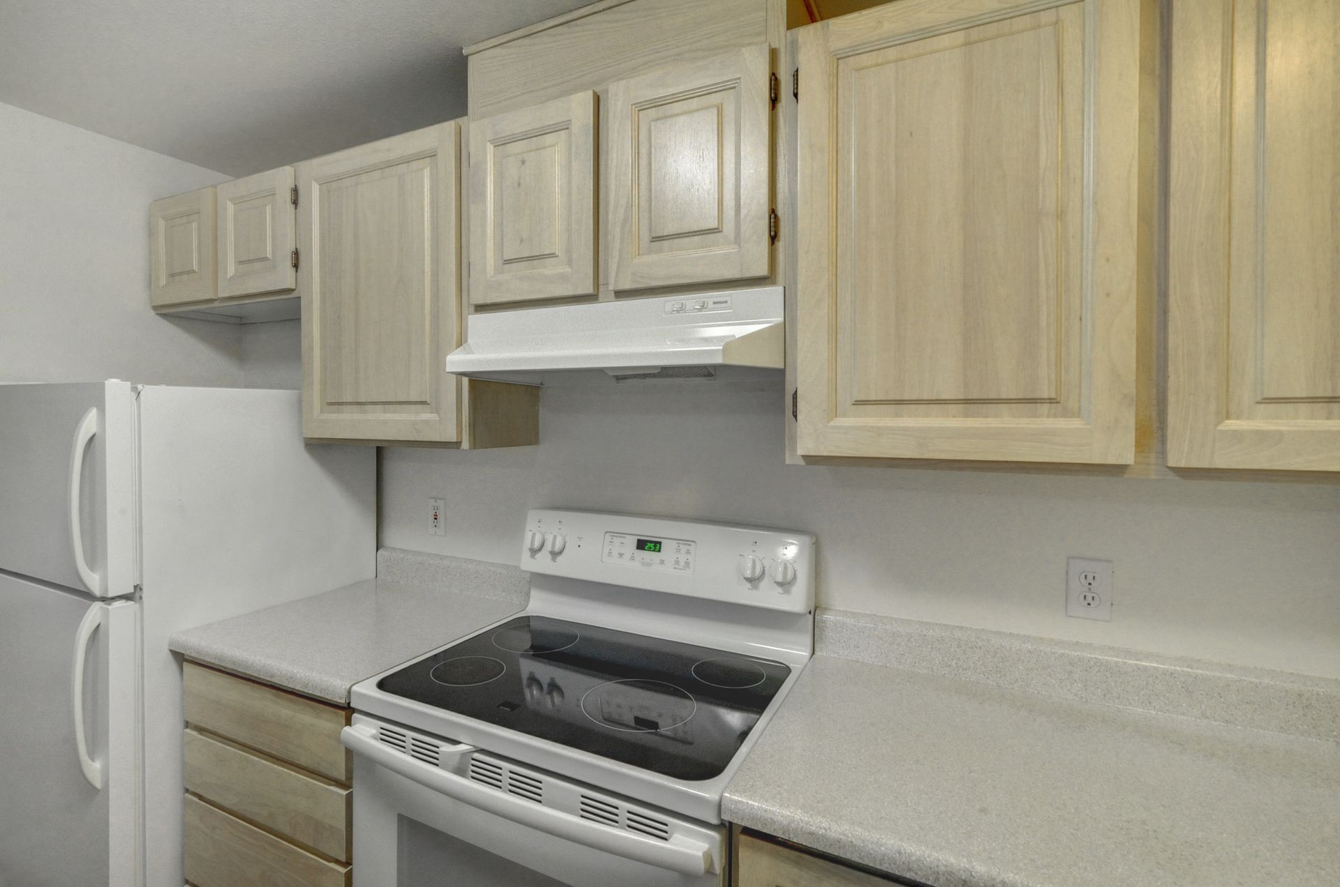 a kitchen with a stove top oven and a refrigerator