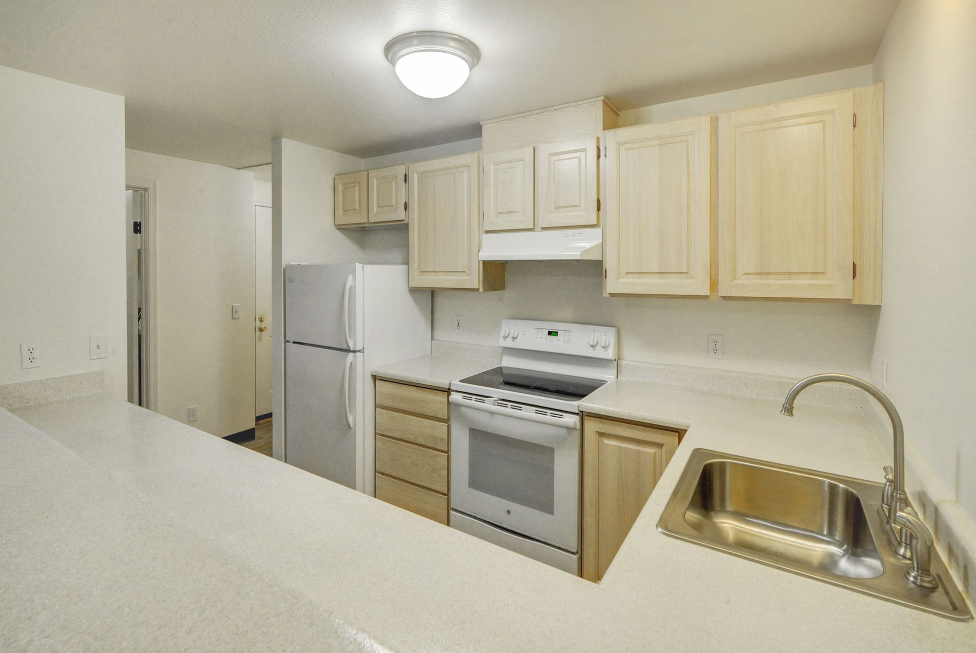 a kitchen with a stove a refrigerator and a sink