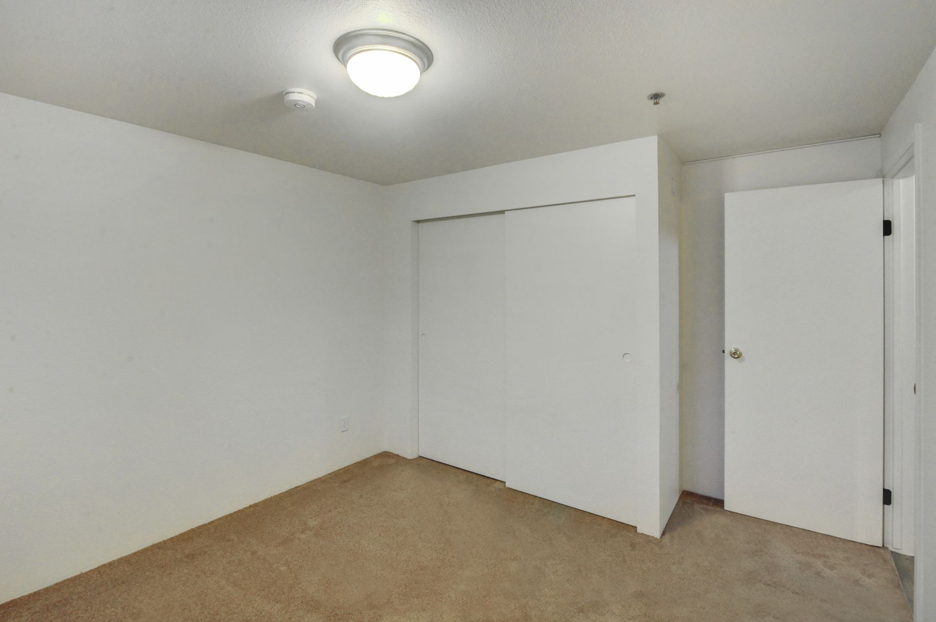 an empty bedroom with a closet and a door