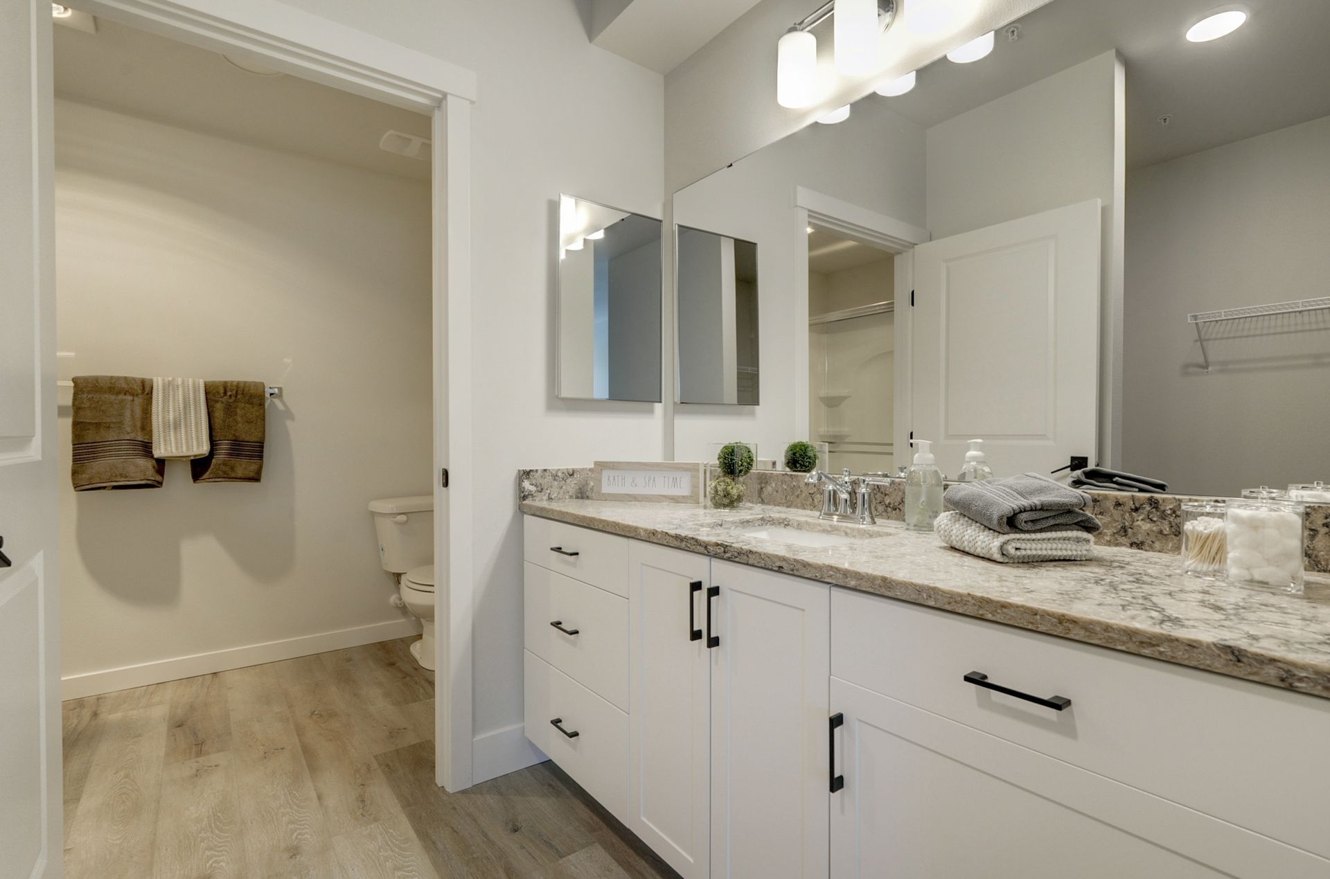 a bathroom with two sinks , a toilet , and a large mirror .