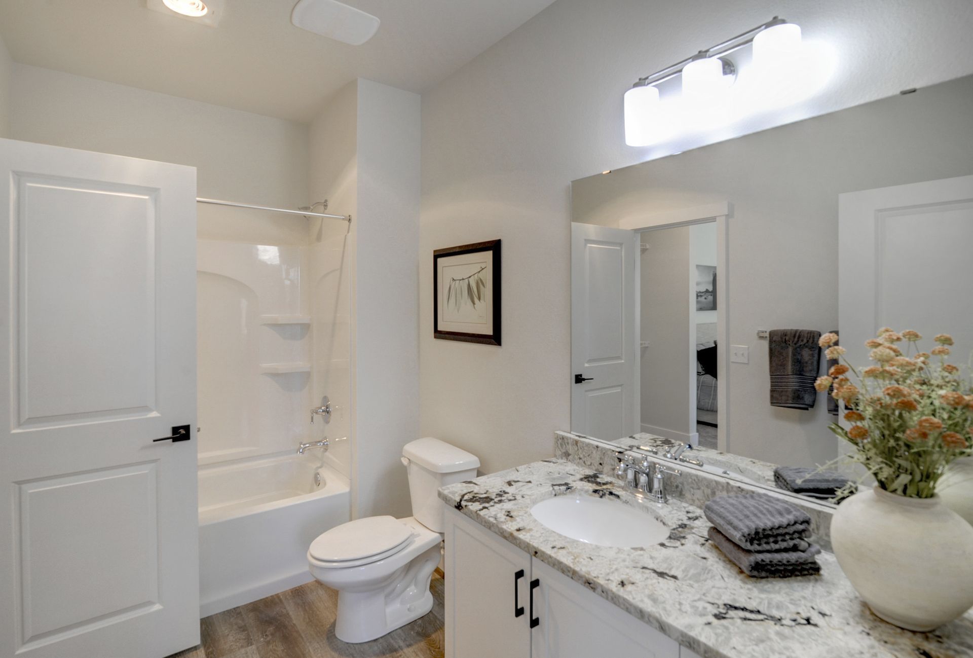 a bathroom with a toilet , sink , bathtub and mirror .