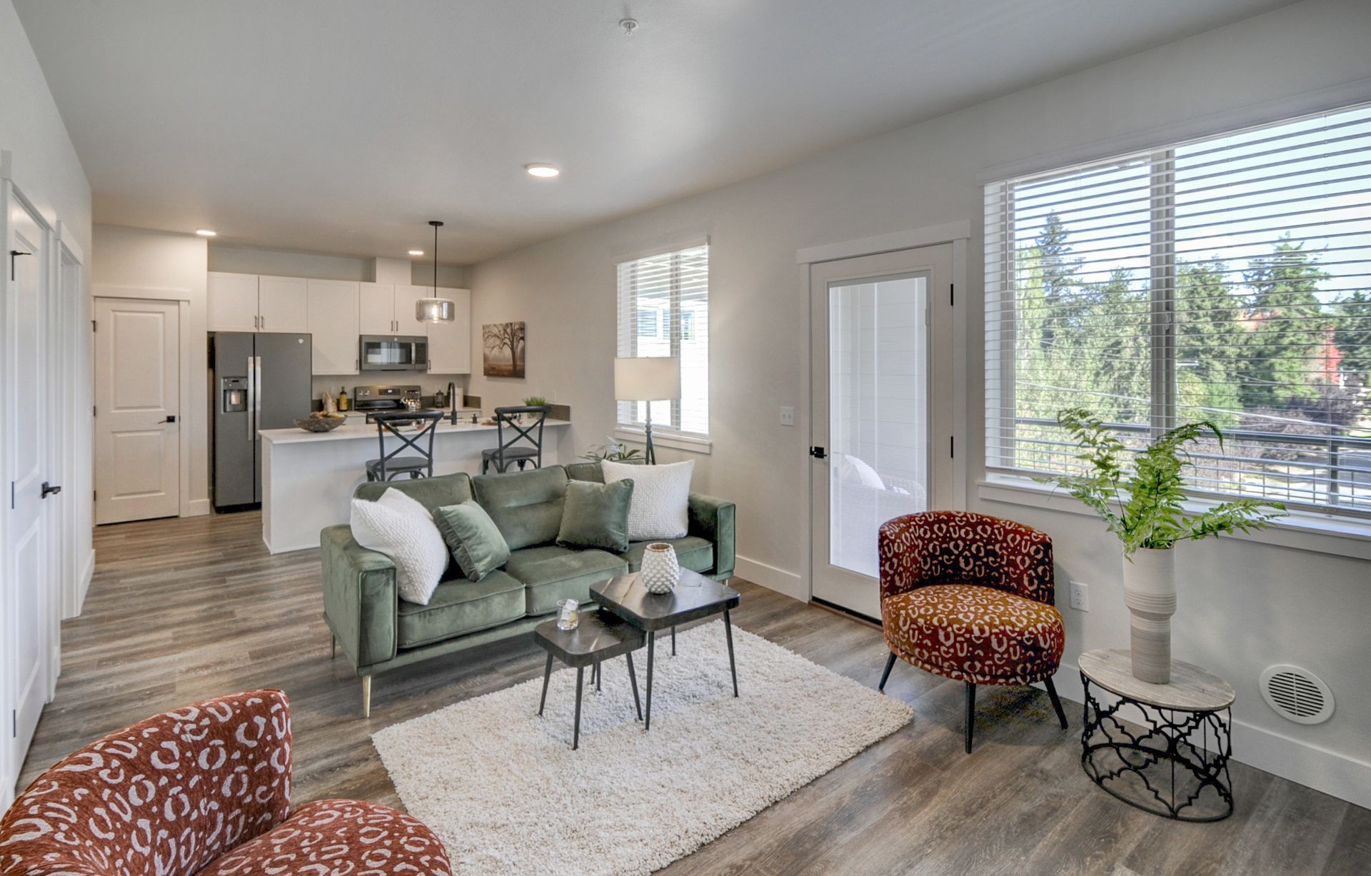 a living room with a couch , chair , table and window .