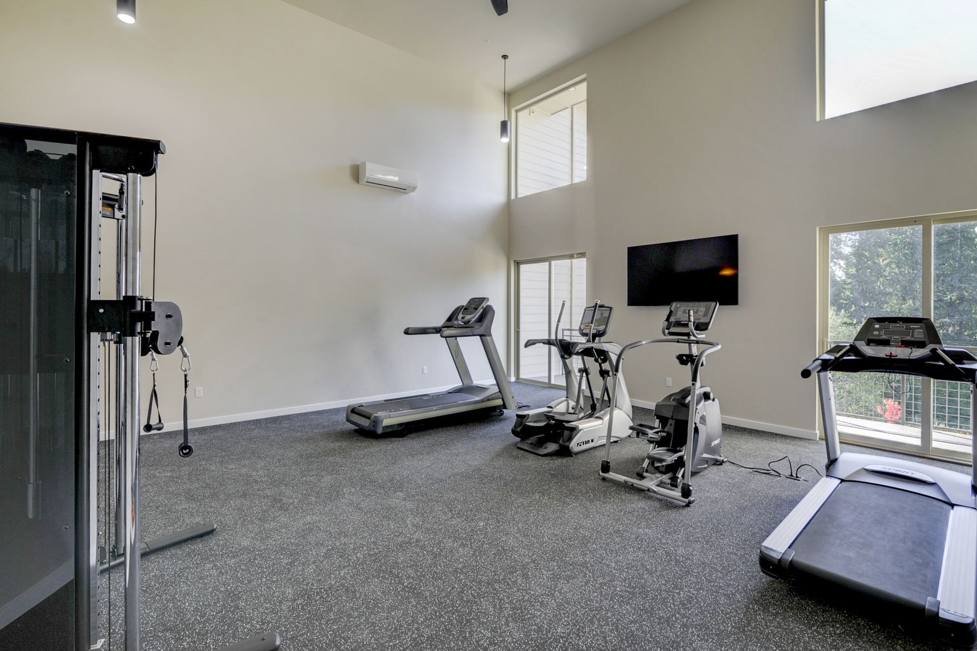 a gym with treadmills , a bike , and a television .