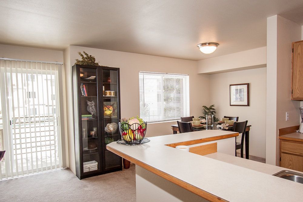 a kitchen with a sliding glass door leading to a dining room
