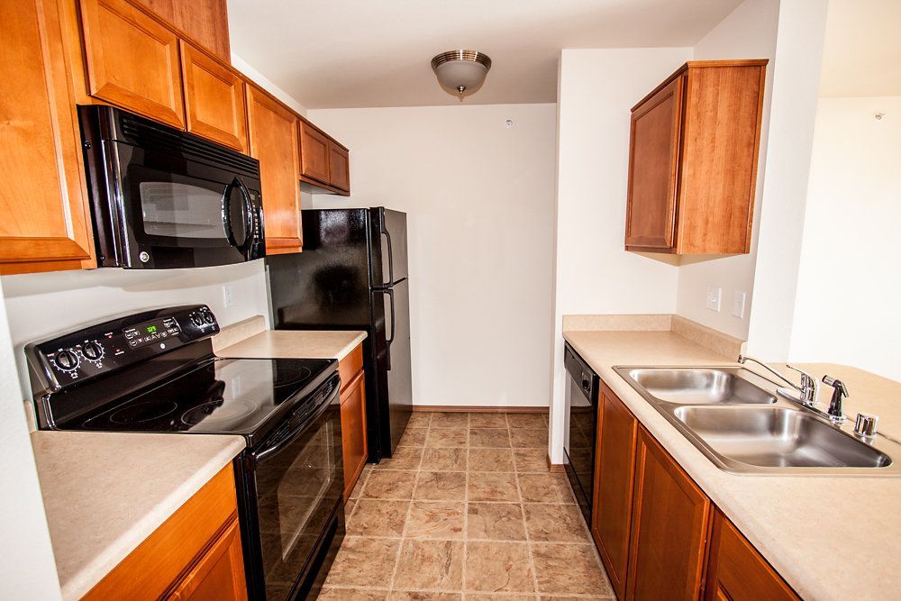 a kitchen with a black stove top oven and a black refrigerator