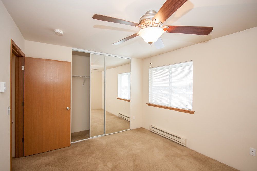 a bedroom with a ceiling fan and a window