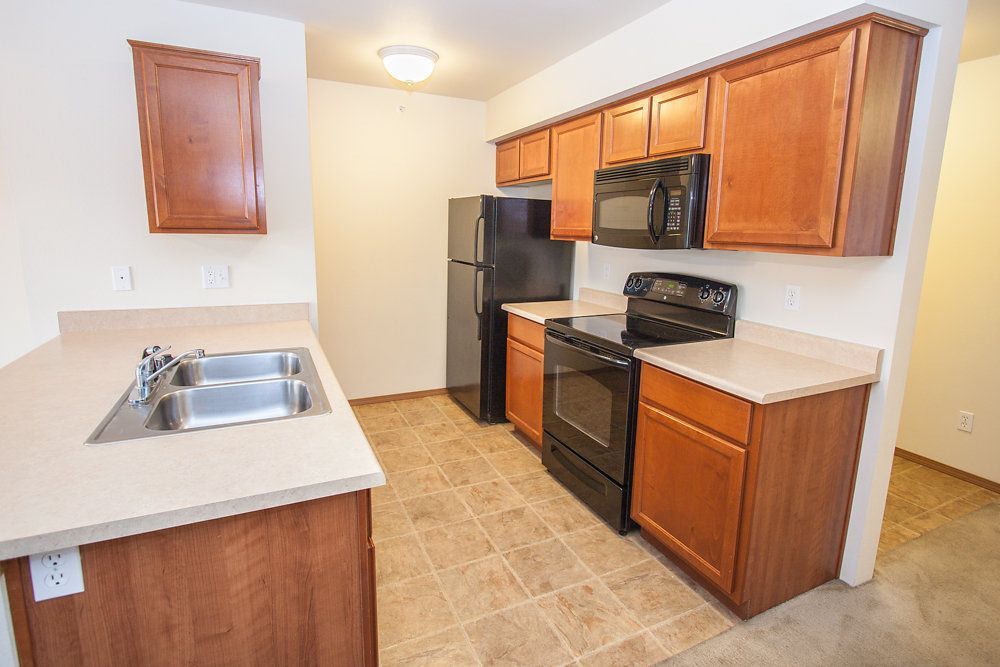 a kitchen with two sinks a refrigerator and a microwave