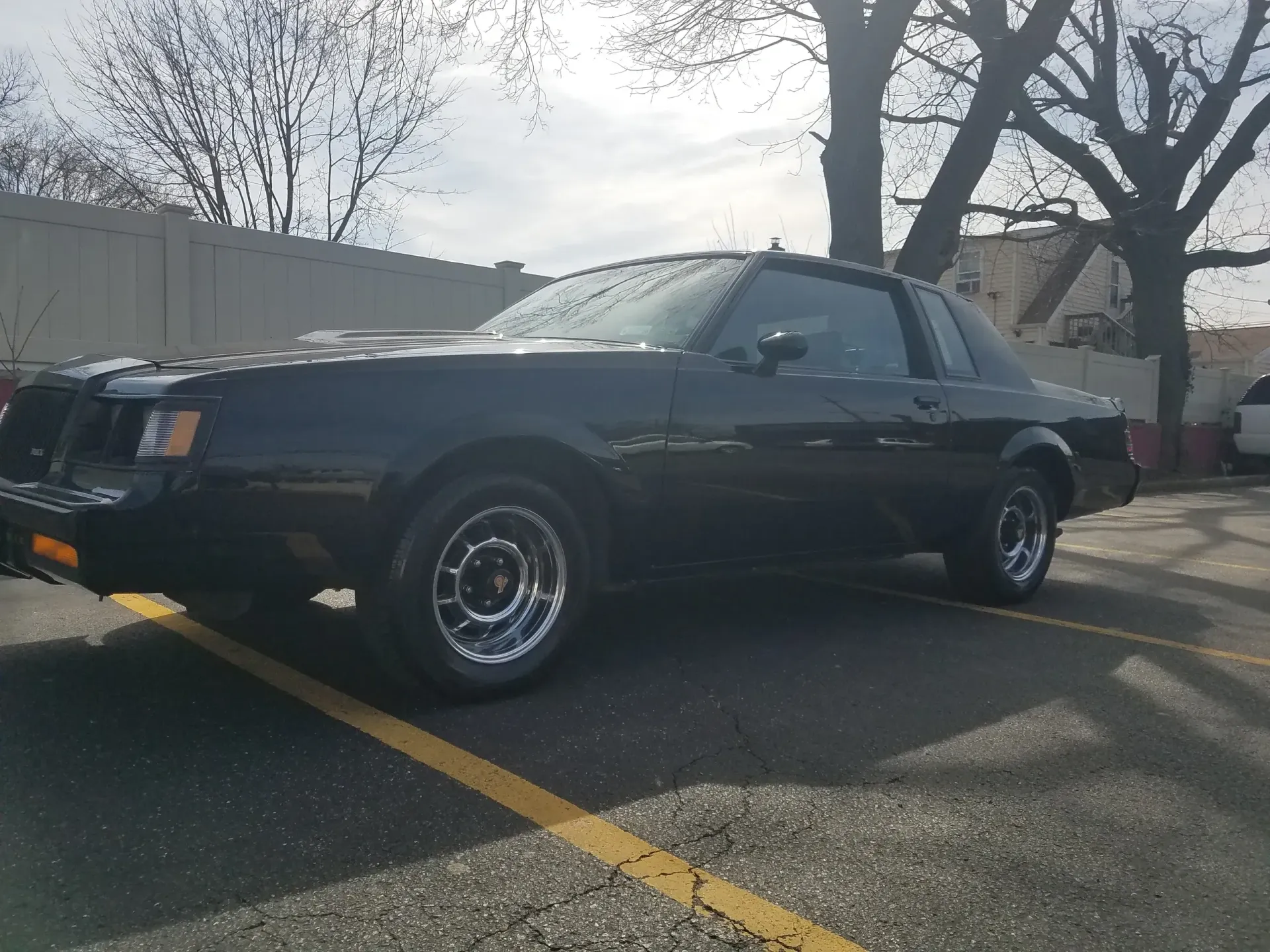 a black car is parked in a parking lot .