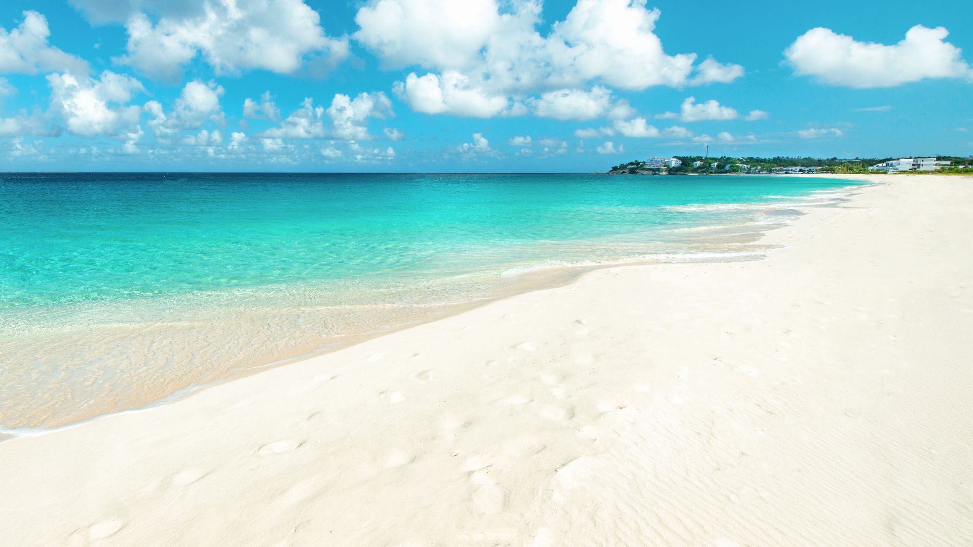 a white sandy beach with a blue ocean in the background