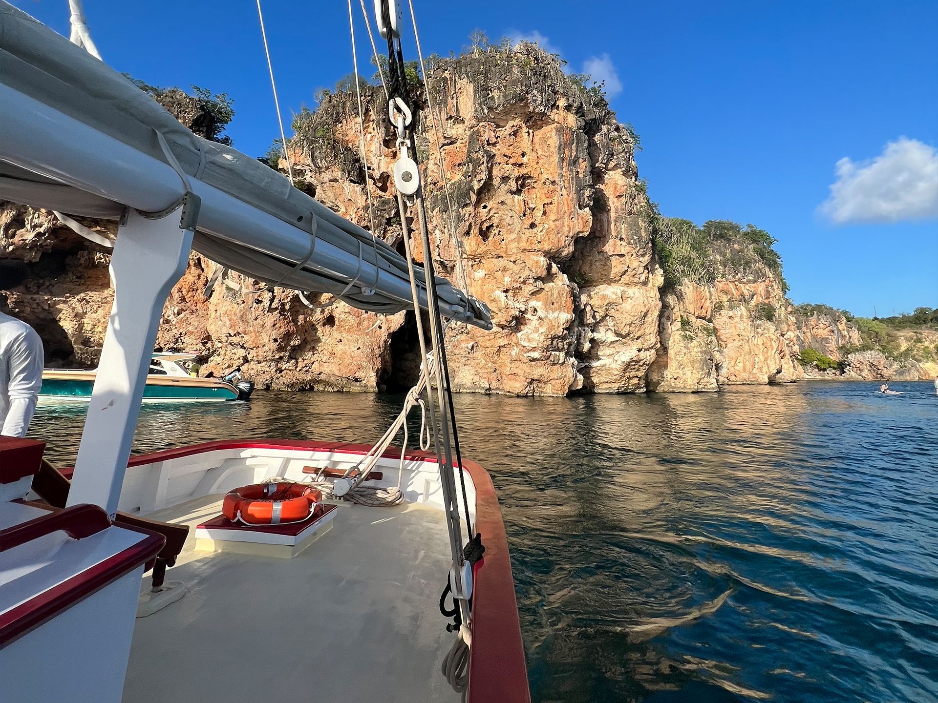 A boat is in the water near a rocky cliff