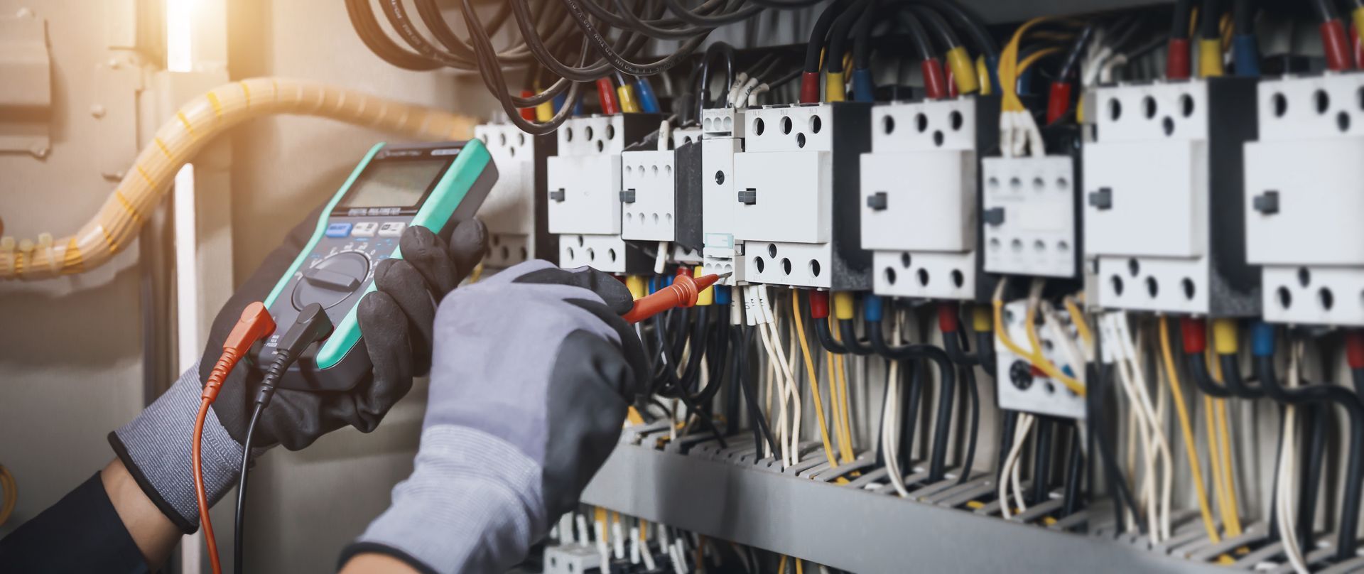 Electrician on scaffold installs wiring in a building under construction. Electrician on a scaffold installing wiring in a construction site.