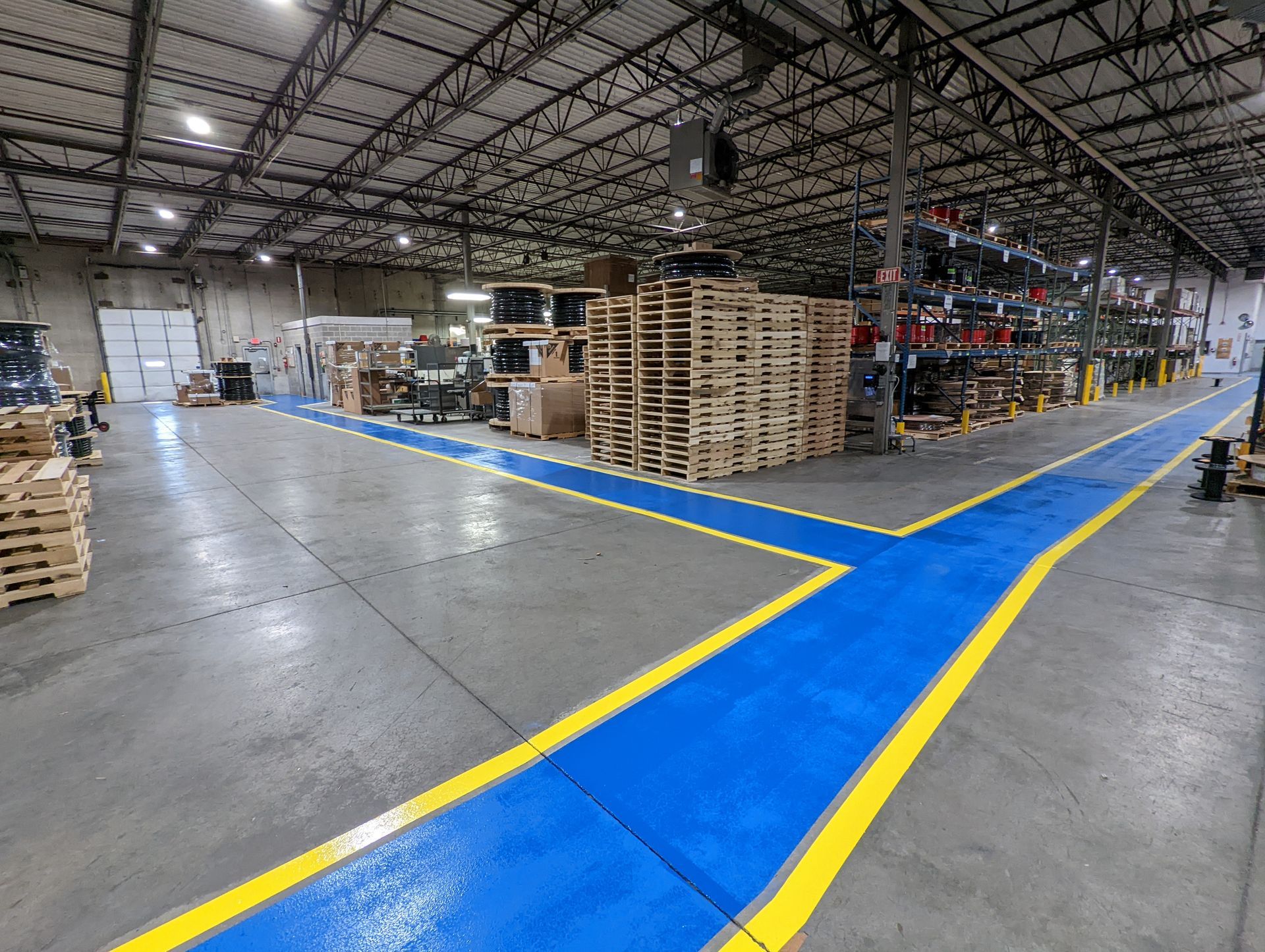 A large warehouse with blue and yellow lines on the floor.