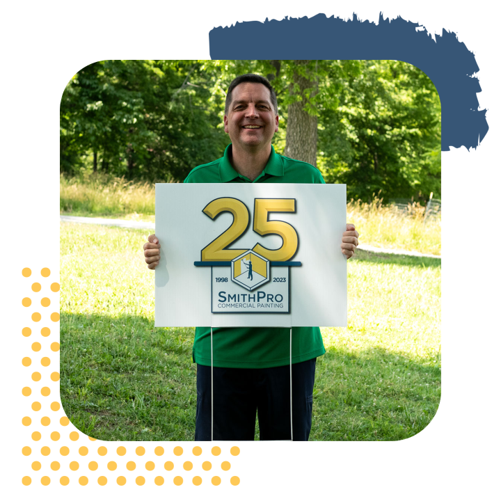 A man in a green shirt is holding a sign that says 25