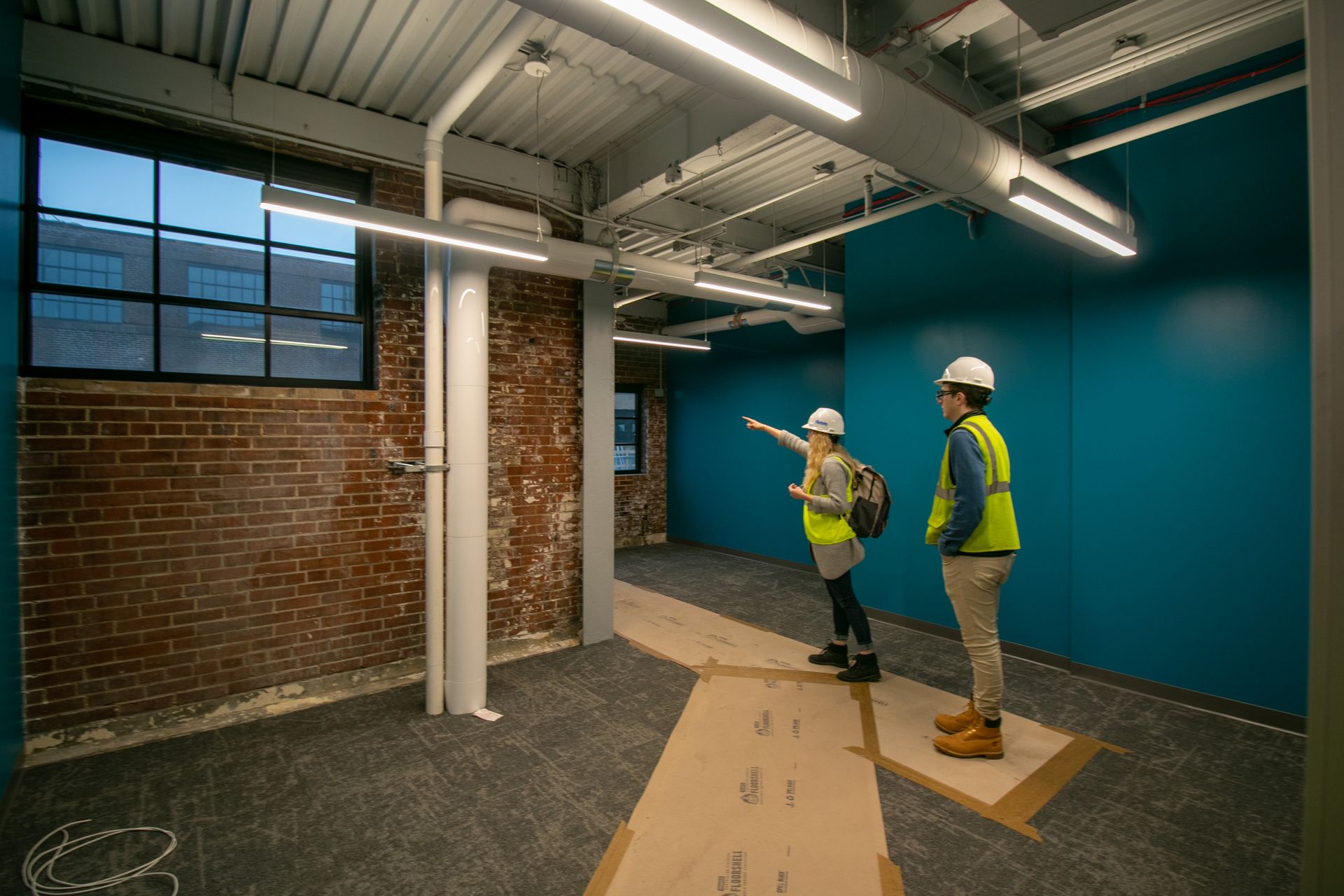 A man and a woman are standing in an empty room.