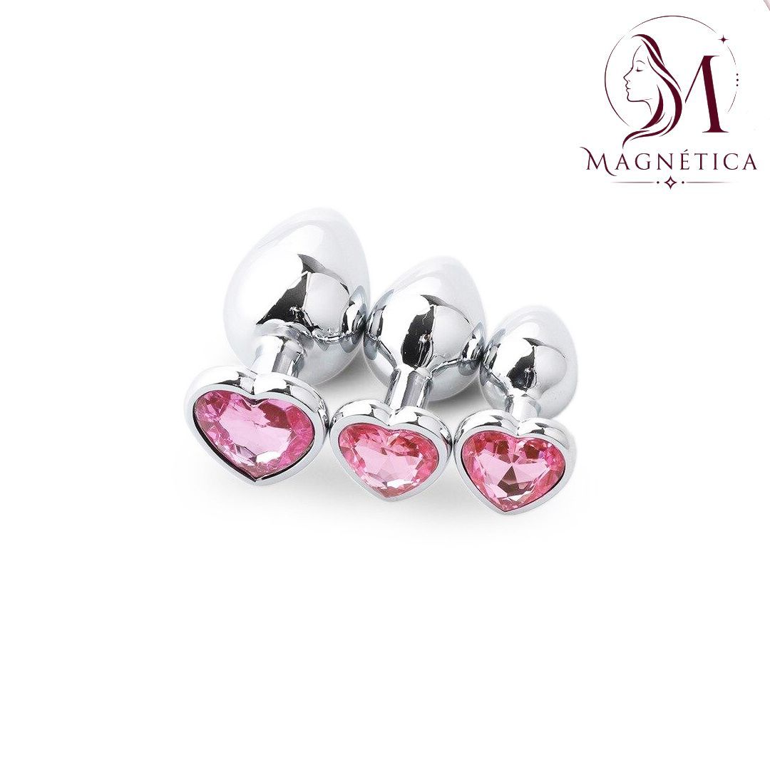 Pendientes de plata y piedras preciosas rosas en forma de corazón sobre fondo blanco.