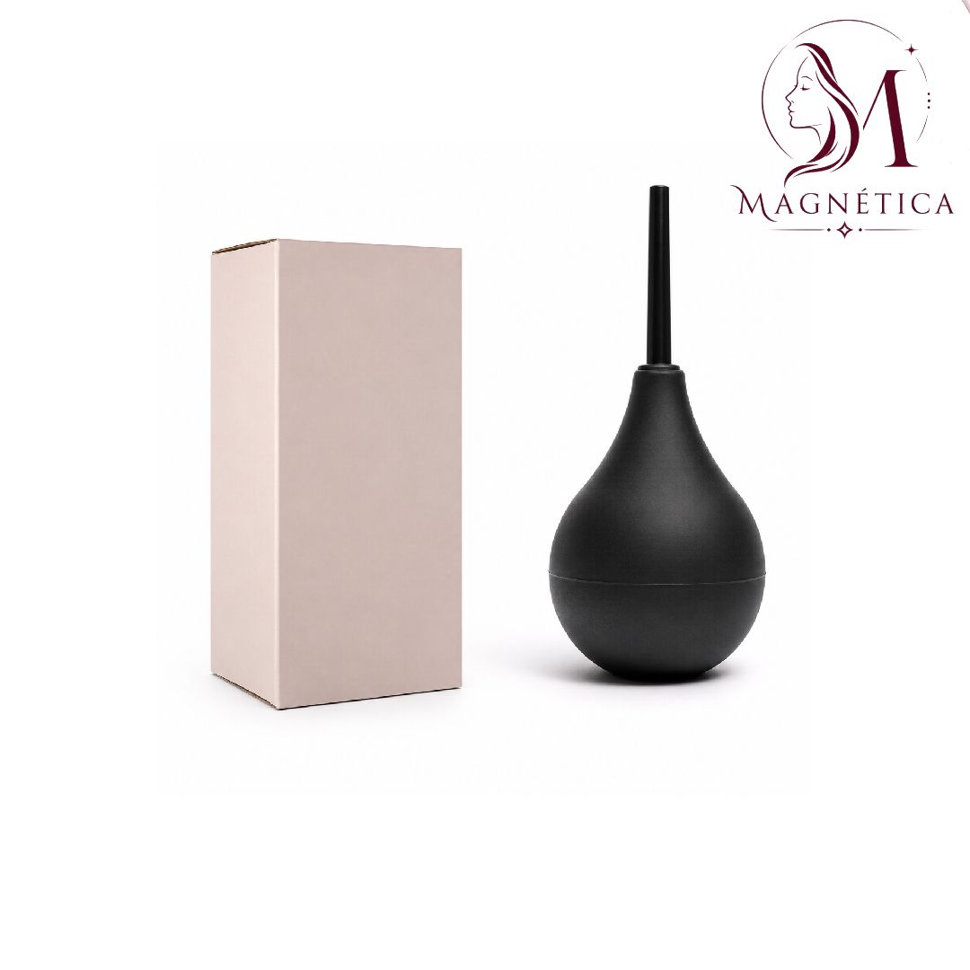 Bombilla negra con forma de bulbo para enema/ducha vaginal con boquilla, junto a una caja beige sobre un fondo blanco.