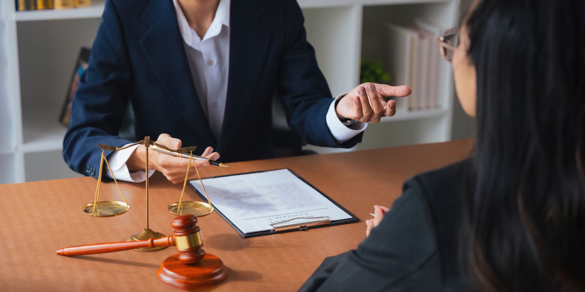 Two business professionals in suits reviewing documents, discussing strategy.