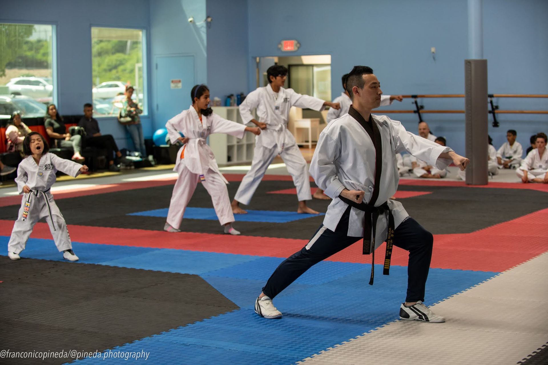 A group of people are practicing martial arts in a gym.