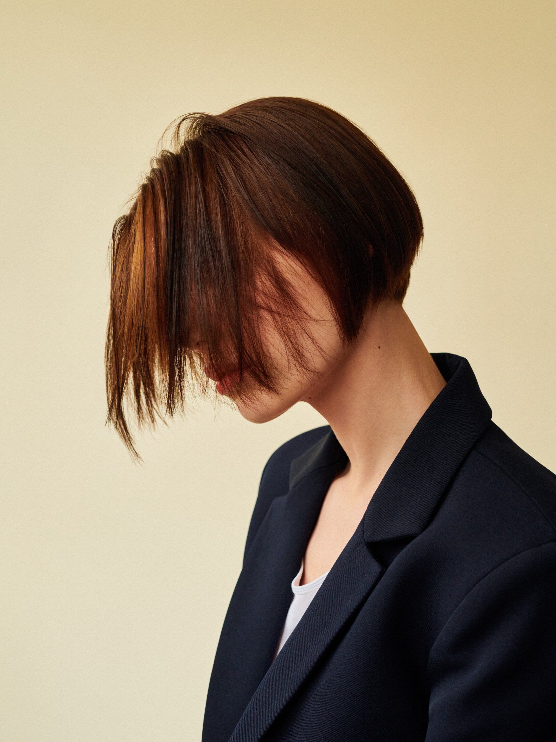 A woman in a black jacket has her hair covering her face