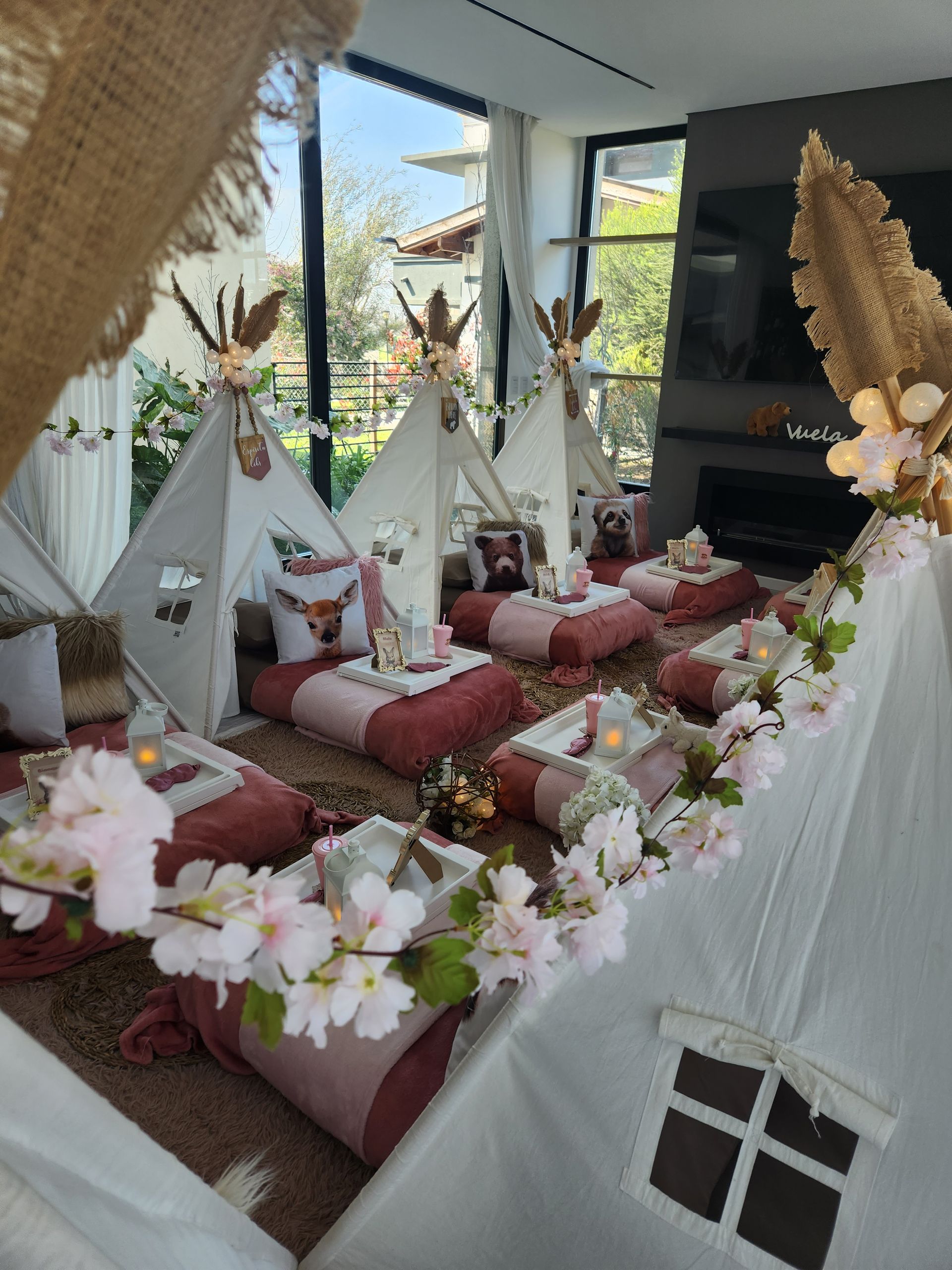 Fiesta de pijamas en tipi de temática bohemia con decoración rosa y blanca dentro de una casa.