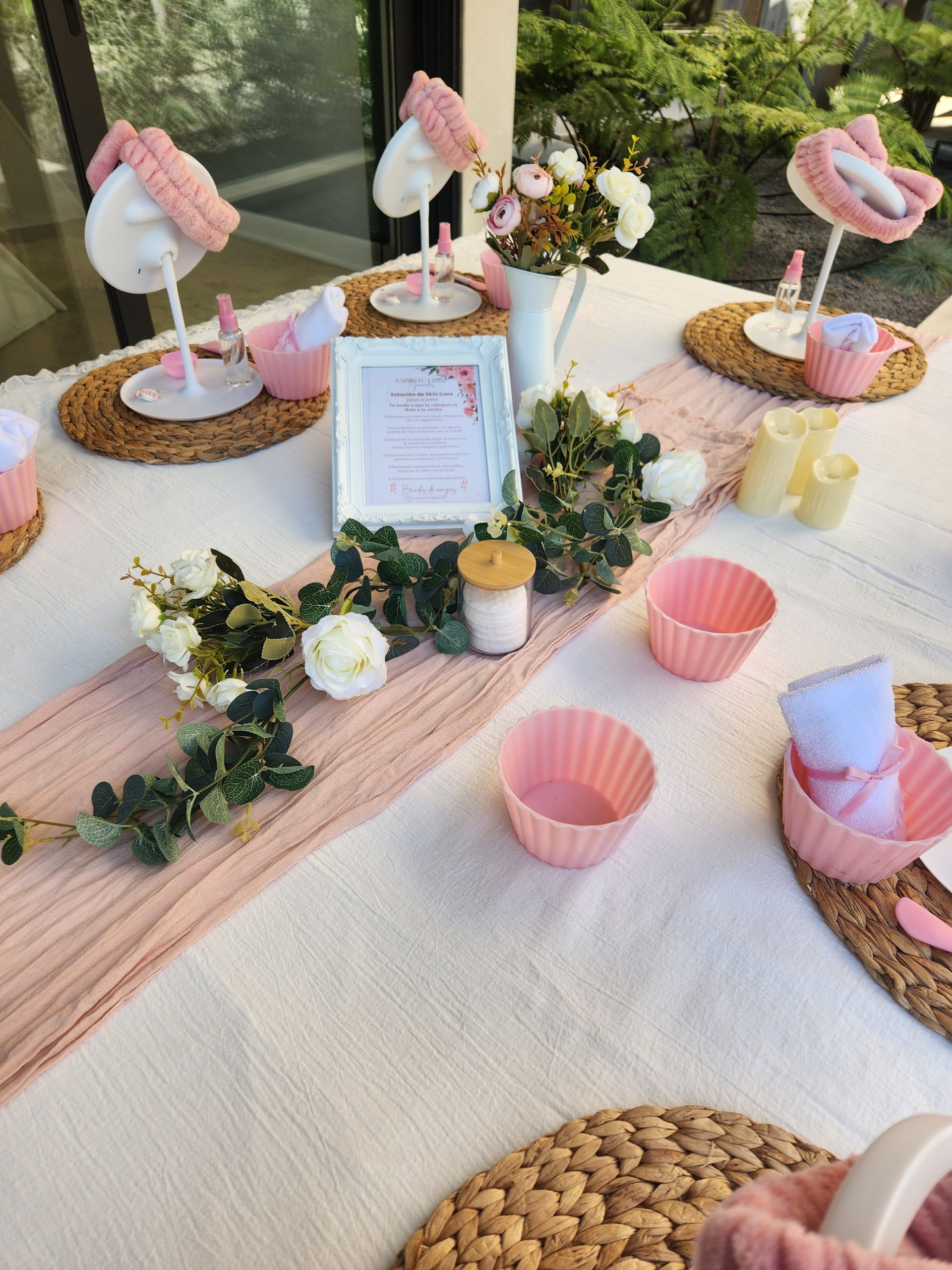 Decoración de mesa en color rosa, con cupcakes, flores y flamencos decorativos.