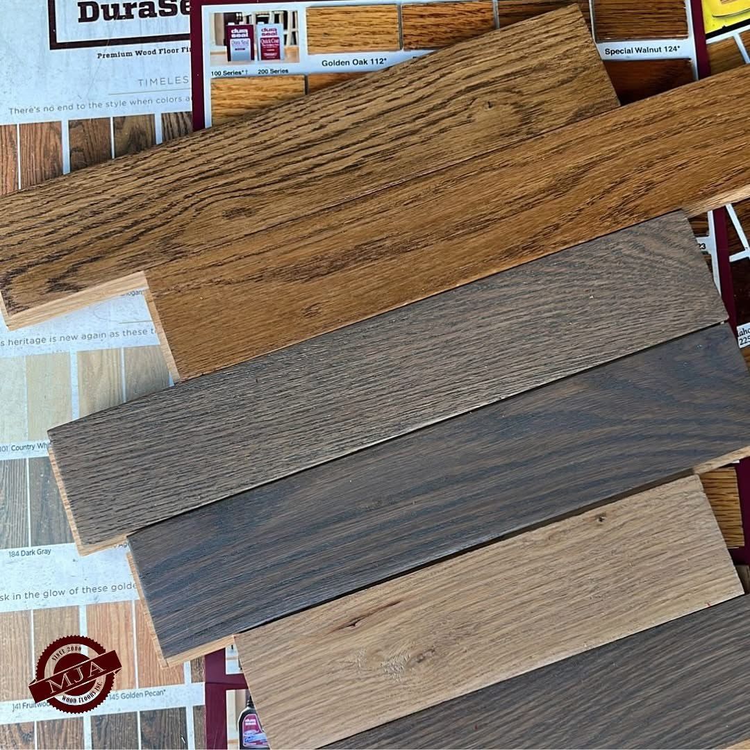 Stacked wood flooring samples in varying shades of brown and gray, set against a promotional DuraSeal background.