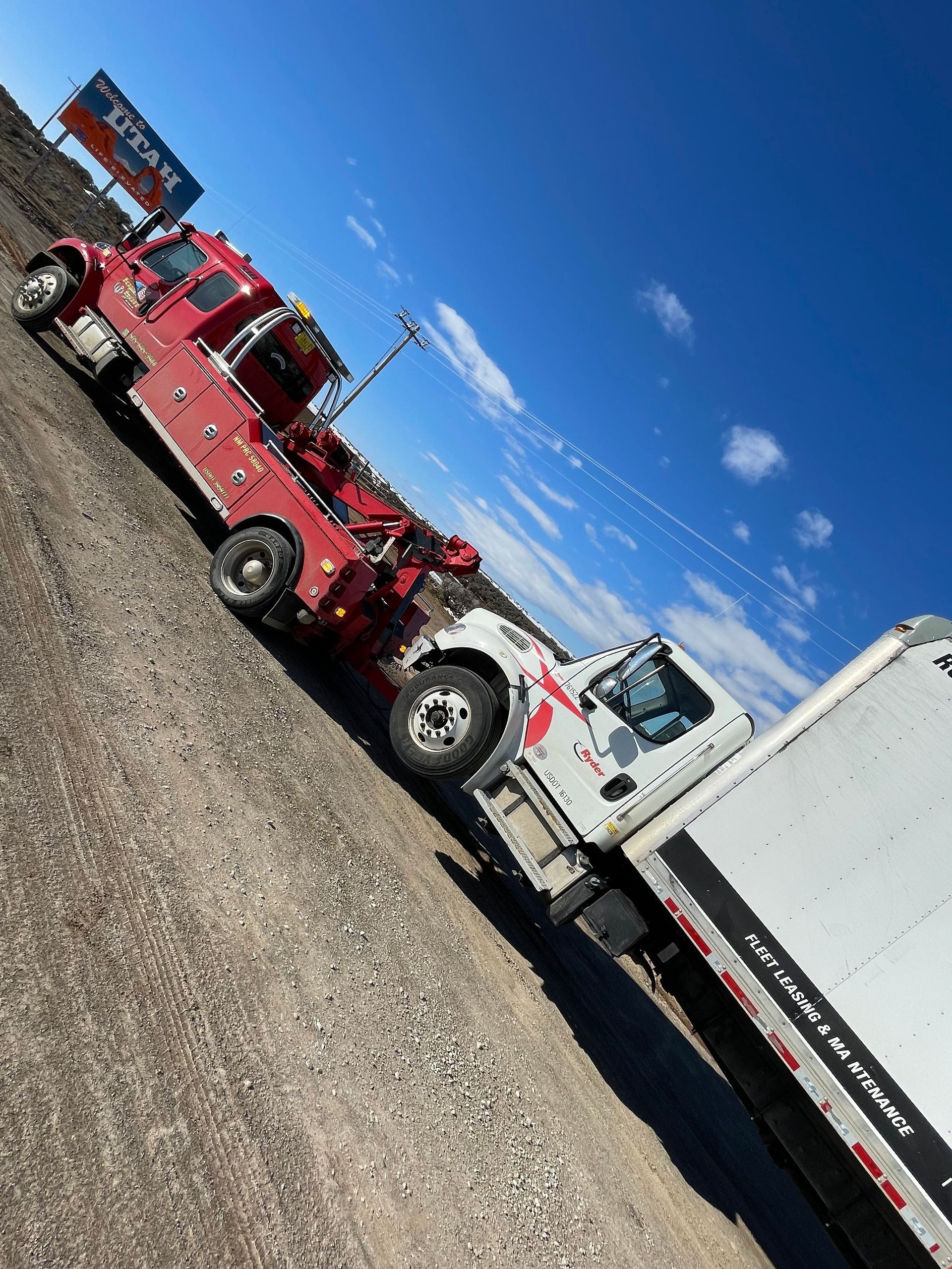 Two tow trucks are parked next to each other on the side of the road.