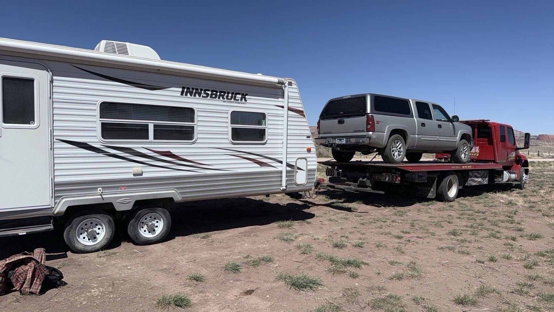A trailer is being towed by a tow truck.