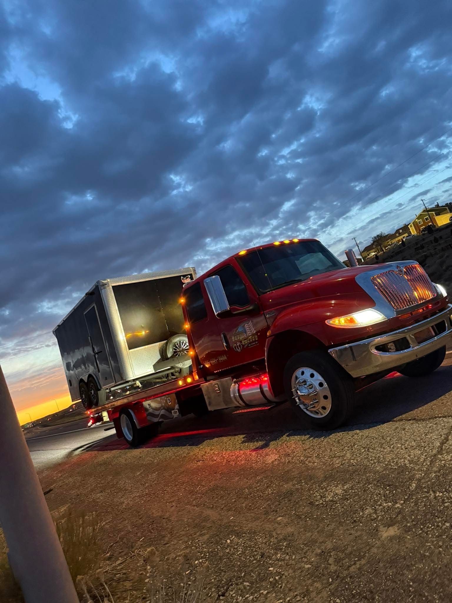 A red tow truck is parked on the side of the road.