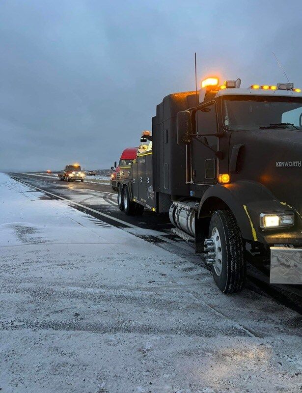 A tow truck is parked on the side of the road