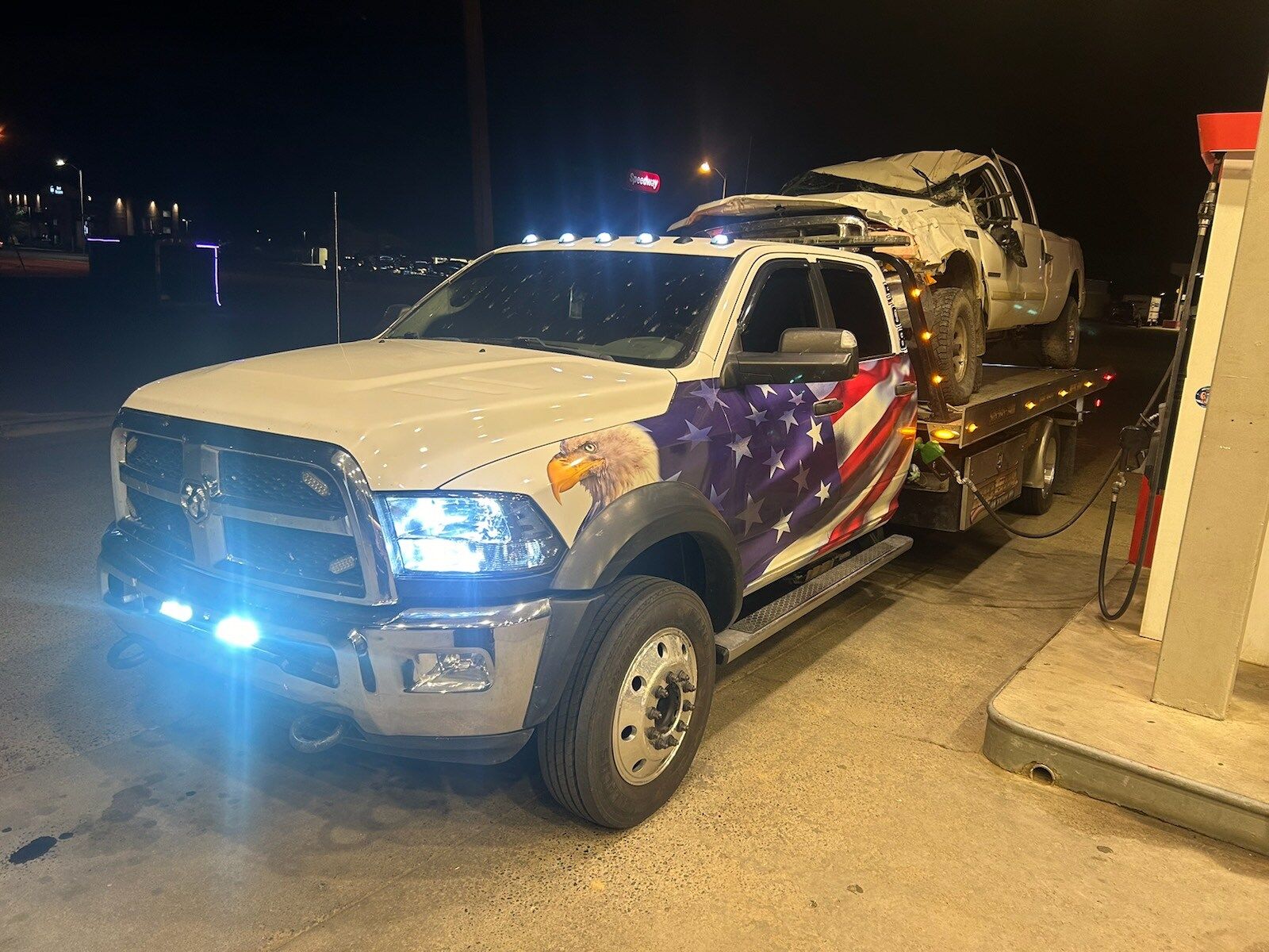 A tow truck is carrying a car on the back of it.
