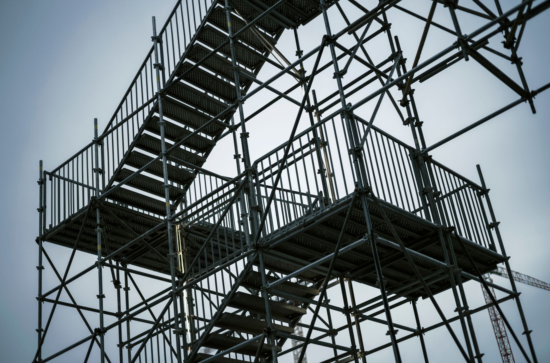 Metal scaffolding with stairs and platforms under clear sky.